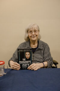 Peggy Overbeck holding The Shaman's Gift novel